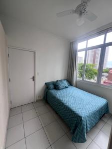 a bedroom with a bed and a window at Apartamento 2 suítes Pitangueiras Guarujá in Guarujá