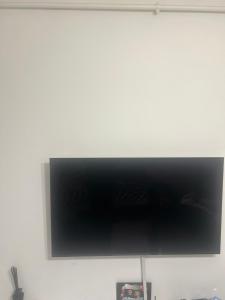フロレシュティにあるApartament Superbの白い壁に掛けられた薄型テレビ