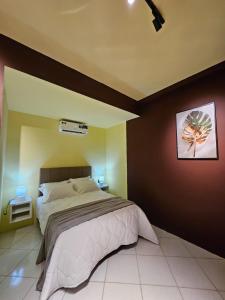 a bedroom with a large bed and a painting on the wall at Praculá Hotel in Belém