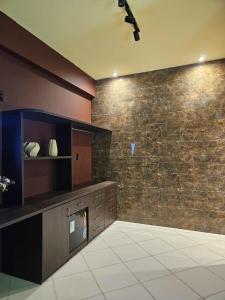 a living room with a tv and a brick wall at Praculá Hotel in Belém