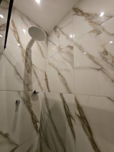 a bathroom with a shower with marble walls at Praculá Hotel in Belém