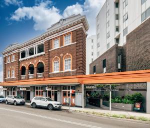 two cars parked in front of a brick building at Strathfield Hotel in Sydney