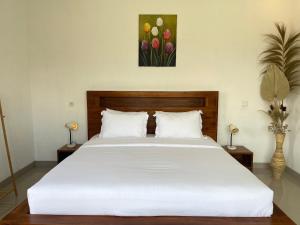 a bedroom with a white bed and a painting of tulips at GreenCaldera - 1BR Guesthouse with Pool in Kintamani in Kubupenlokan +31 photos