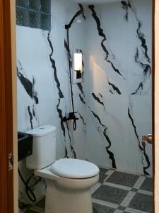 a bathroom with a toilet and a black and white wall at Arum Bromo Villas in Ngadisari +38 photos