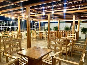 un restaurante con mesas de madera y sillas con luces en Hotel Casa Lopez - Cartagena, en Cartagena de Indias