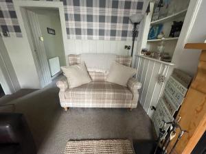 a living room with a couch with two pillows at Moulin Cottage in Pitlochry