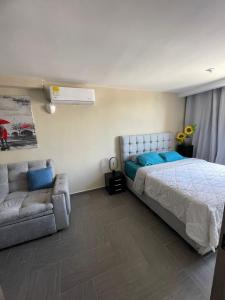 a bedroom with a bed and a couch at Moderno Apto con Aire Acondicionado Vista a Ruitoque cerca a FOSCAL in Floridablanca