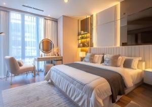 a bedroom with a large white bed and a chair at Arvesto Jakarta in Jakarta