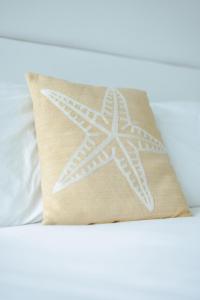 a pillow with a white star on top of a bed at Serenity Rincon Guesthouse in Rincon