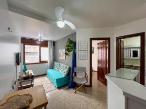 uma sala de estar com um sofá azul e uma mesa em Pé na areia em Capão da Canoa