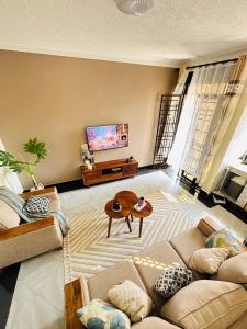 a living room with a couch and a flat screen tv at True's cozy homes in Kira