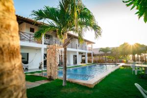 dom z basenem i palmą w obiekcie Milano Hotel Pousada Canoa Quebrada w mieście Canoa Quebrada