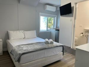 une chambre avec un lit avec deux chaussures dessus dans l'établissement Proserpine Motel, à Proserpine