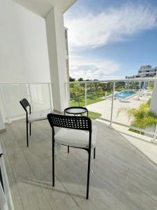 two chairs and a table on a balcony with a view at 1 Bedroom Apartment with spectacular pool and golf course view in Punta Cana
