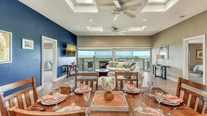 a dining room with a table and chairs and a couch at Siesta Sunset - 524 (PH) in Siesta Key