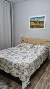 Un dormitorio con una cama con una colcha floral. en Casa no centro da Serra do Cipó, en Santana do Riacho