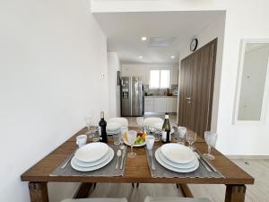 a dining room table with white plates and wine glasses at 1 Bedroom Apartment with spectacular pool and golf course view in Punta Cana +38 photos