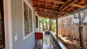 Un porche de una casa con una silla y un techo. en Casa no centro da Serra do Cipó, en Santana do Riacho