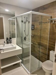 a bathroom with a shower and a toilet and a sink at Carpe Diem Boutique - Dúplex Hidro e Varanda in Campos do Jordão