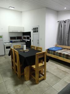 a room with a table and a kitchen with a bed at Sinaí Apart in Santa Rosa de Calamuchita