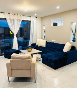a living room with a blue couch and a table at Villa design avec jardin et espaces lumineux in Seyssel