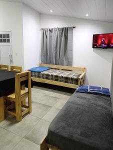 a room with two beds and a tv on the wall at Sinaí Apart in Santa Rosa de Calamuchita