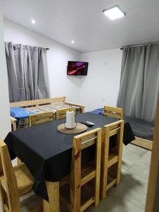 a dining room with a black table and chairs at Sinaí Apart in Santa Rosa de Calamuchita +3 photos