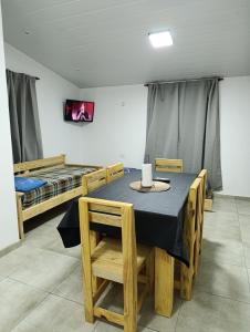 a dining room with a table and two beds at Sinaí Apart in Santa Rosa de Calamuchita