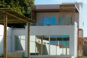 ein modernes Haus mit Glasfassade in der Unterkunft Casa de Verão - Praia de Muriú in Muriú + 9 Fotos