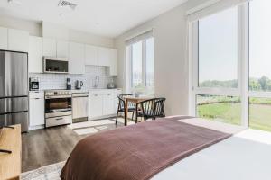 1 dormitorio blanco con cocina y mesa en Blueground Revere courtyard games wd ac BOS-1092, en Boston