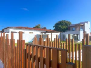 una recinzione di legno di fronte a una casa di Casa de Verão - Praia de Muriú a Muriú Altre 9 foto