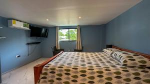 a bedroom with a bed in a room with a tv at Olas del alba in Tapantí