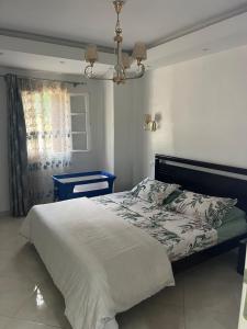 a bedroom with a bed and a chandelier at Beautiful quiet apartment in El Harrach
