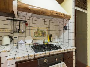 a kitchen with a stove and a white tiled wall at Alla Corte del Re in Naples