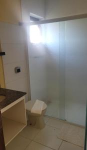 Un baño con inodoro y ducha de cristal. en PeruíBella Pousada, en Peruíbe
