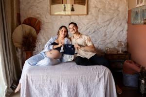 a man and a woman sitting on a bed at Chalé Cabana studio Jundiaí louveira Campinas 2 in Jundiaí