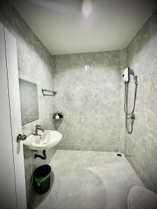ナイヤンビーチにあるDa Airport Hotelの洗面台とシャワー付きのバスルーム