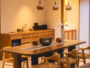a wooden table with chairs and a vase of flowers on it at Glamday style hotel suite 山ノ麓 in Karuizawa