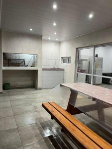 cocina grande con mesa de madera y banco en Quinta in Sauce Viejo, aire libre, 