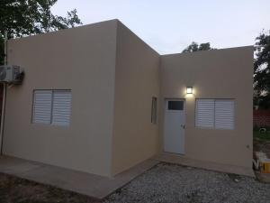 un edificio con una puerta y dos ventanas en Quinta in Sauce Viejo, aire libre,  1 foto más