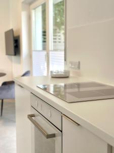 eine weiße Küche mit einer Spüle und einer Theke in der Unterkunft Heide Apartment Heimat in Schneverdingen