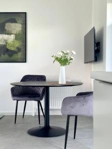 ein Esstisch mit einer Vase mit Blumen darauf in der Unterkunft Heide Apartment Heimat in Schneverdingen