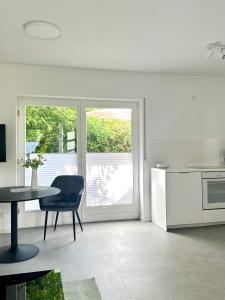 eine Küche mit einem Tisch, einem Tisch und einem Stuhl in der Unterkunft Heide Apartment Heimat in Schneverdingen