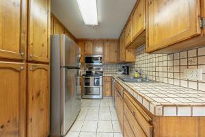 Una cocina con gabinetes de madera y un refrigerador de acero inoxidable. en 254 Bldg D townhouse, en Donner Lake Village