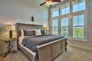 a bedroom with a bed with a ceiling fan and windows at Prominece 30A - Coasting Inn in Watersound Beach +44 photos