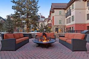a patio with two couches and a fire pit at Luxury Ski In, Ski Out 2 Bedroom Mountain Residence In The Heart Of Lionshead Village With Heated Slope Side Pool And Hot Tub in Vail