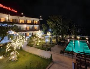 a resort with a swimming pool at night at Intimate Riverside Resort Vang Vieng in Vang Vieng