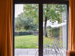 a door leading to a patio with a table and chairs at Stone Cottage in Wingerworth