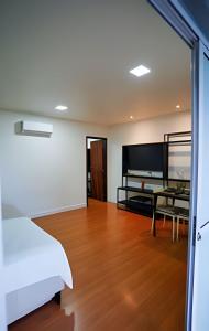 une chambre avec un lit et une table dans une pièce dans l'établissement Flat Exclusivo com Piscina Privativa e Vista Incrível, à Fernando de Noronha