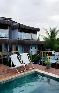 une terrasse avec deux chaises longues à côté d'une piscine dans l'établissement Flat Exclusivo com Piscina Privativa e Vista Incrível, à Fernando de Noronha